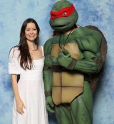 Summer Glau posing with a fan cosplaying as a Ninja Turtle